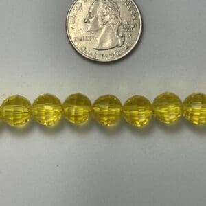 Yellow glass beads with quarter for scale.