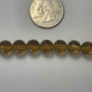 Amber glass beads with quarter for scale.