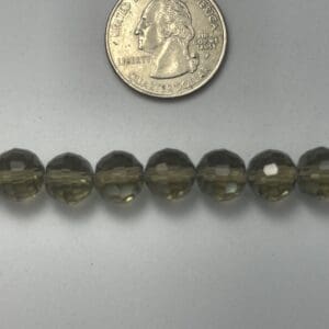 Smoky quartz beads with quarter for scale.