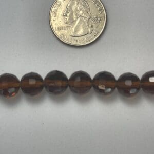 Brown faceted glass beads with quarter.