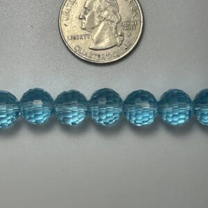 Light blue faceted beads with quarter.