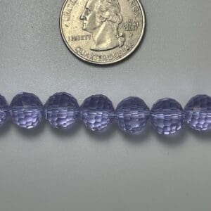 Purple glass beads with quarter for scale.