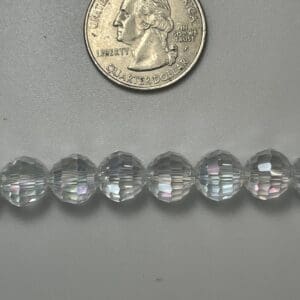 Clear faceted beads with quarter for scale.