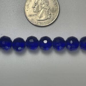 Here's an alt tag for the image: Cobalt blue faceted glass beads.