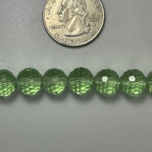 Light green faceted beads with quarter.