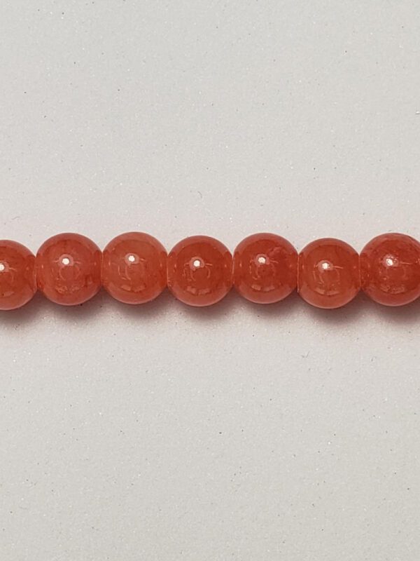 Here's an alt tag for the image: Orange gemstone beads row.