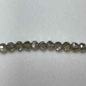 Here's an alt tag for the image: Row of dark gray glass beads.