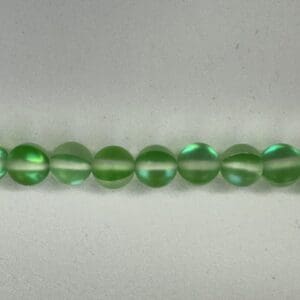 Row of pale green glass beads.