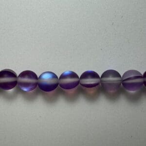 Row of iridescent purple glass beads.