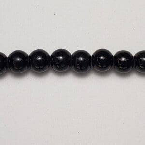 Black round beads on white background.