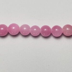 Pink gemstone beads, row of seven.