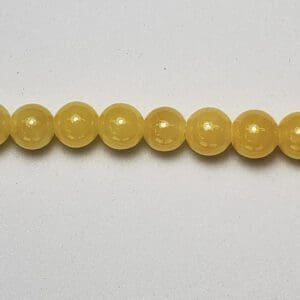Pale yellow round beads in a row.