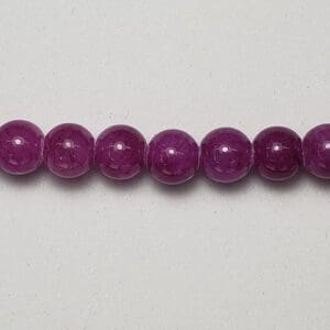 Purple gemstone beads on white background.
