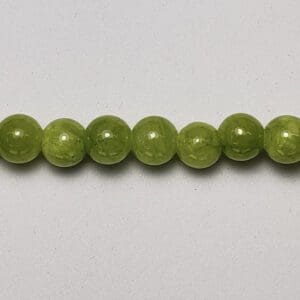Green jade beads on white background.