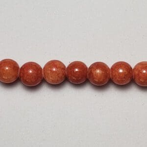 Row of reddish-brown coral beads.