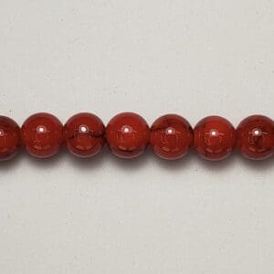 Red glass beads on white background.