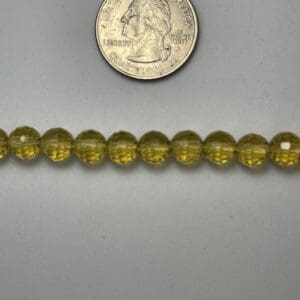 Yellow glass beads with quarter for scale.
