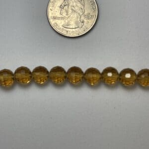 Amber glass beads with quarter for scale.