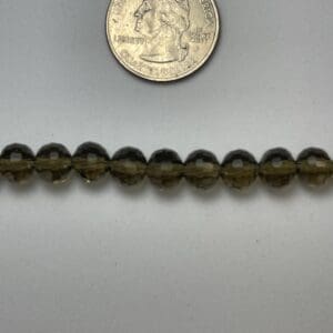 Smoky quartz beads with quarter for scale.