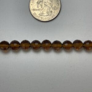 Amber glass beads with quarter for scale.
