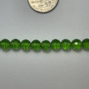 Green glass beads with quarter for scale.