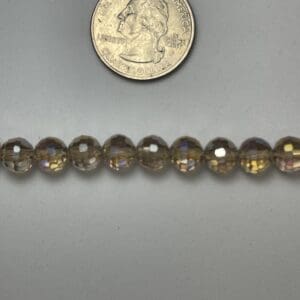 Here's an alt tag for the image: Amber glass beads, size comparison.