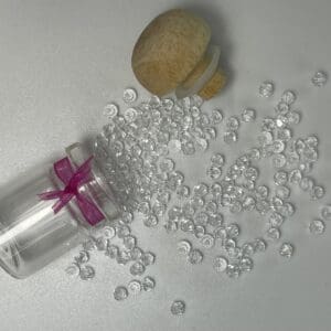 Clear beads spilling from glass jar.