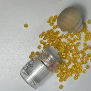 Yellow glass beads in a bottle.