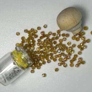 Amber glass beads spilled from jar.