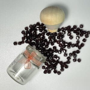 Dark brown beads in jar with wooden knob.