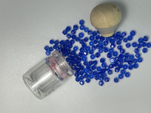 Blue glass beads in a small jar.