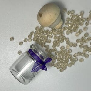 Glass jar, wooden top, and beige beads.