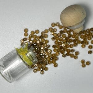 Amber beads in glass jar with wood stopper.