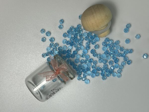 Light blue beads spilling from jar.