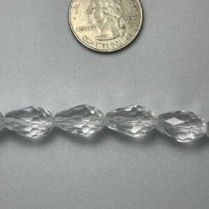 Clear faceted beads with quarter for scale.