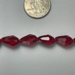 Red faceted glass beads with quarter.