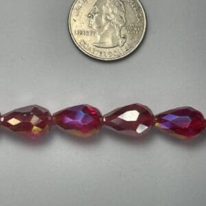 Red glass beads with quarter for scale.