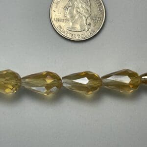 Golden teardrop glass beads with quarter.