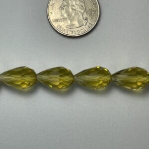 Here's a short alt tag for the image: Green glass pear beads with quarter.