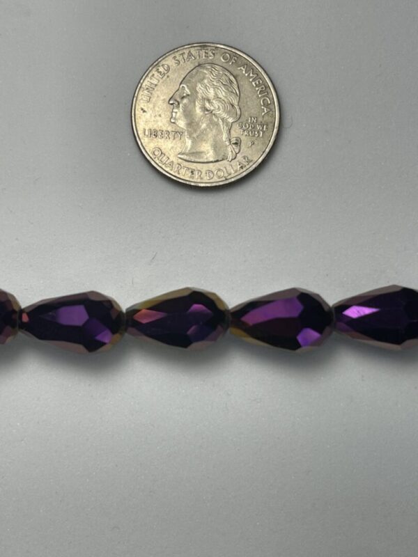 Purple teardrop beads with quarter for scale.