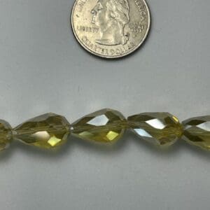 Olive green faceted glass beads, size comparison.