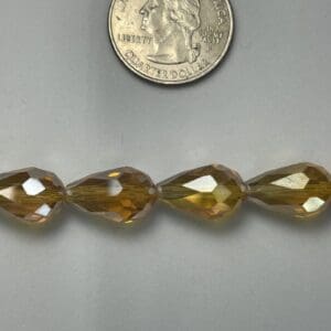Four amber teardrop glass beads.