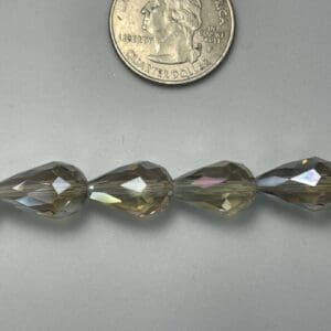 Four iridescent teardrop beads with quarter.