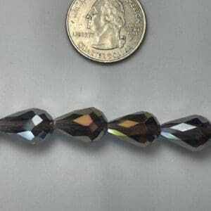 Dark teardrop glass beads size comparison.
