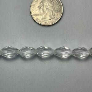 Clear faceted beads with quarter for scale.