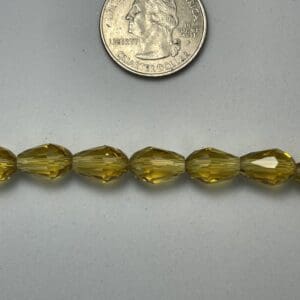 Yellow faceted glass beads with quarter.