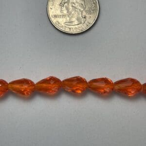 Orange teardrop beads size comparison.