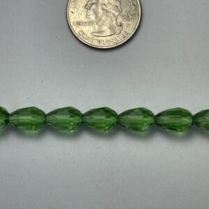 Green glass beads with quarter for scale.