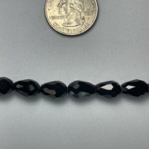 Black faceted glass beads with quarter.