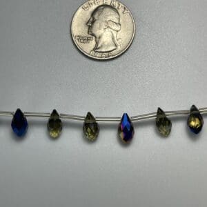 Pear-shaped iridescent glass beads on wire.